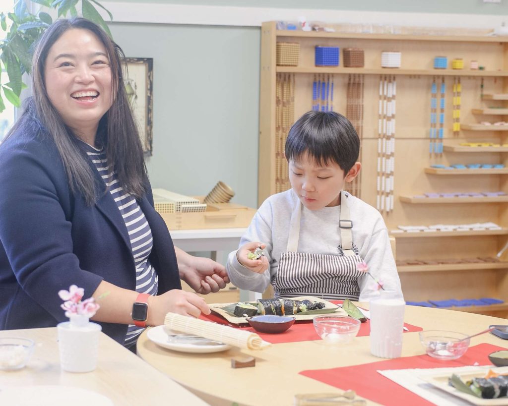 Montessori parent and child enjoy a sushi-making activity together at Guidepost Montessori Mahwah.